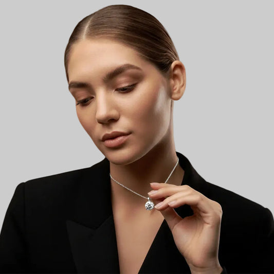 Woman wearing a necklace with a diamond pendant on a plain background